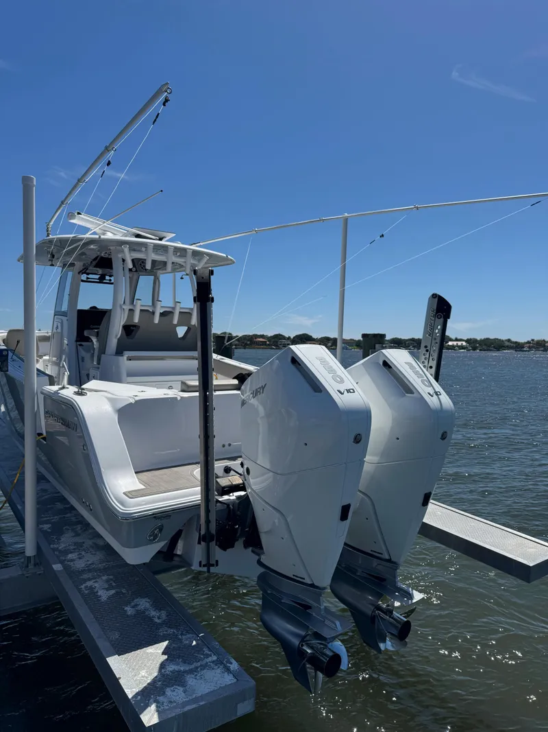 Slide: The Image of 2024 Sportsman 302 boat with dual Mercury engines docked on a sunny day. - 7
