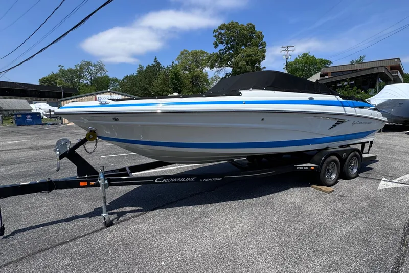 The Image of 2023 Crownline 240 SS boat on trailer in parking lot, sunny day. - 0