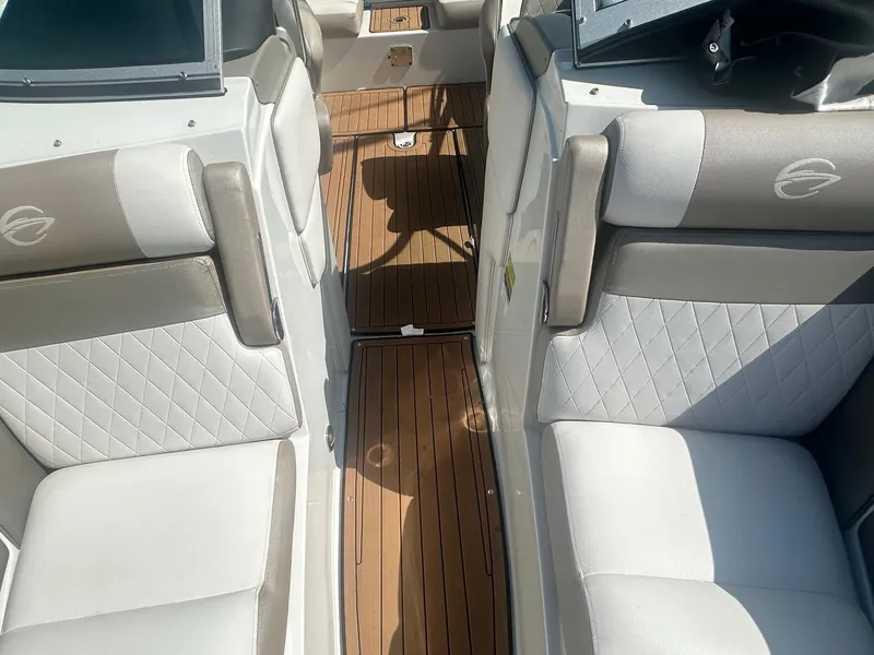 Slide: The Image of 2023 Crownline 240 SS boat interior with white and gray seating, wood flooring. - 21