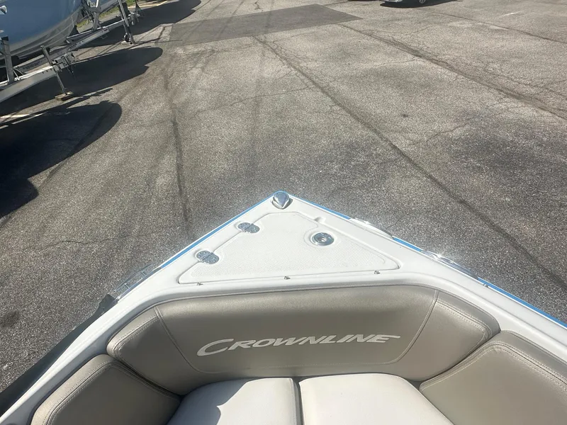 Slide: The Image of 2023 Crownline 240 SS boat bow with seating, parked on asphalt. - 22