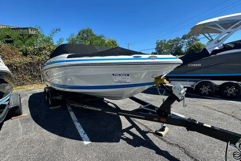 Slide: The Image of 2023 Crownline 240 SS boat on trailer, covered and for sale in parking lot. - 3