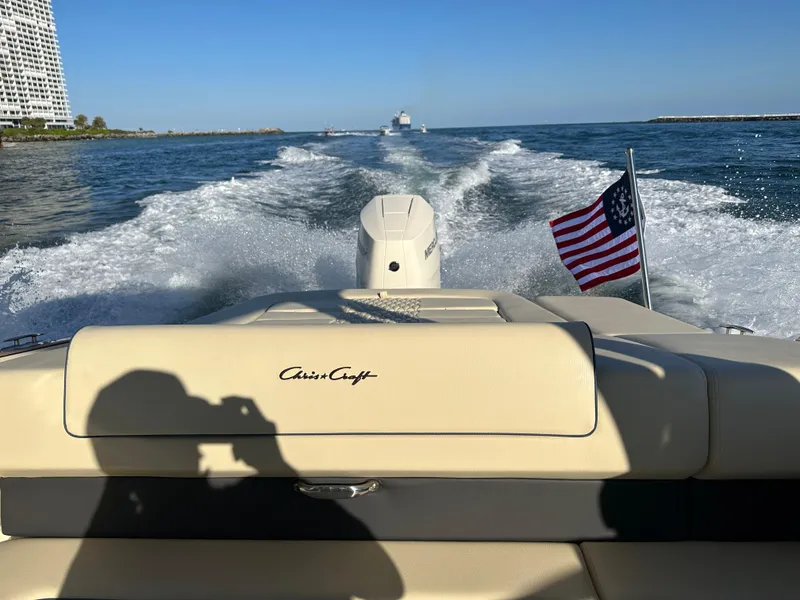 Slide: The Image of 2025 Chris-Craft Sportster 28 cruising on open water with American flag. - 6