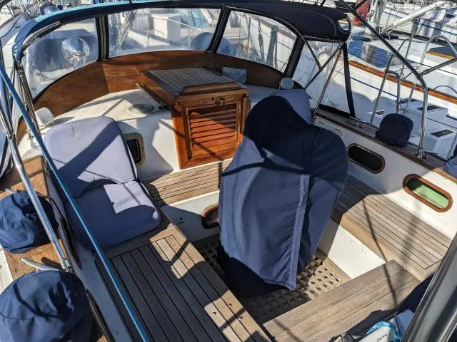 Slide: The Image of 1981 Kelly Peterson 44 sailboat cockpit with wooden seating and covered helm. - 11