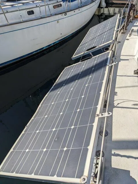 Slide: The Image of Solar panels on a 1981 Kelly Peterson 44 sailboat docked at a marina. - 16