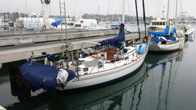 Slide: The Image of 1981 Kelly Peterson 44 sailboat docked in a marina, covered and ready for sailing. - 23