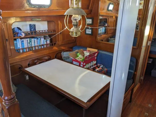 Slide: The Image of Interior of 1981 Kelly Peterson 44 sailboat with dining area and bookshelves. - 3