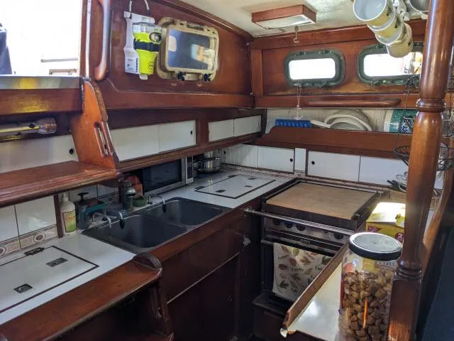 Slide: The Image of Interior of 1981 Kelly Peterson 44 sailboat kitchen with wooden cabinetry and appliances. - 6