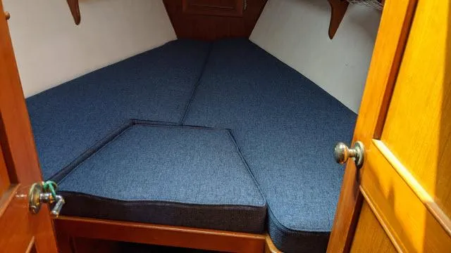 Slide: The Image of V-berth cabin with blue cushions in a 1981 Kelly Peterson 44 sailboat. - 7