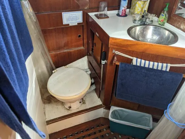 Slide: The Image of 1981 Kelly Peterson 44 yacht bathroom with sink, toilet, and wooden cabinetry. - 8
