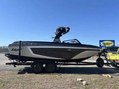 Slide: The Image of 2021 Tigé 23ZX boat on trailer, parked outdoors under clear blue sky. - 4