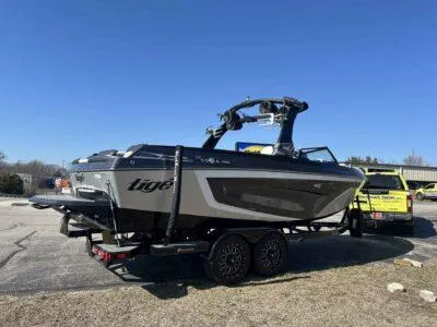 Slide: The Image of 2021 Tigé 23ZX boat on trailer under clear blue sky. - 5