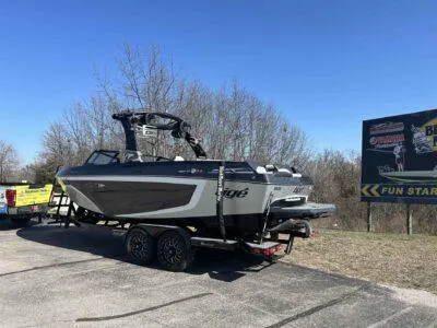 Slide: The Image of 2021 Tigé 23ZX boat on trailer, parked outdoors under clear blue sky. - 6