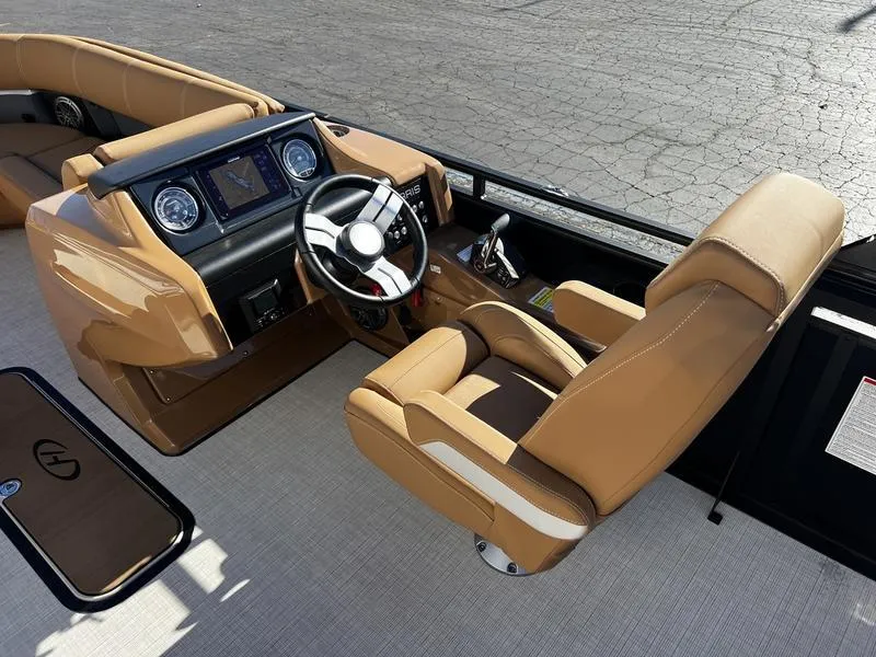 Slide: The Image of 2024 Harris Solstice 230 boat interior with tan seating and modern dashboard. - 14