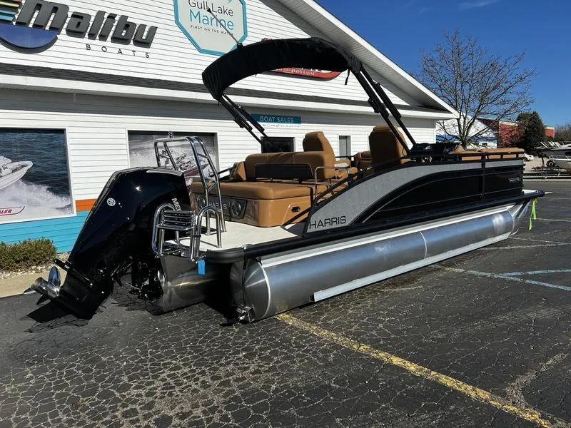 Slide: The Image of 2024 Harris Solstice 230 pontoon boat parked at a marina, featuring sleek design and modern amenities. - 2