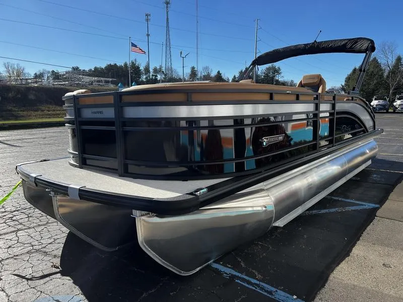 Slide: The Image of 2024 Harris Solstice 230 pontoon boat parked on asphalt under clear blue sky. - 6