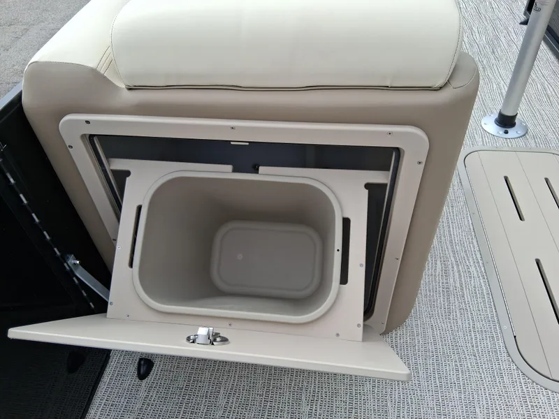 Slide: The Image of SunCatcher Select 324RC 2025 boat storage compartment with open lid and beige interior. - 11
