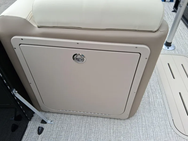 Slide: The Image of 2025 SunCatcher Select 324RC boat storage compartment with beige cushioned seating. - 12