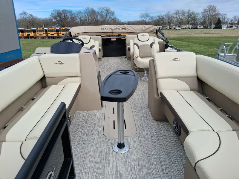 Slide: The Image of 2025 SunCatcher Select 324RC pontoon boat with beige seating and central table. - 5