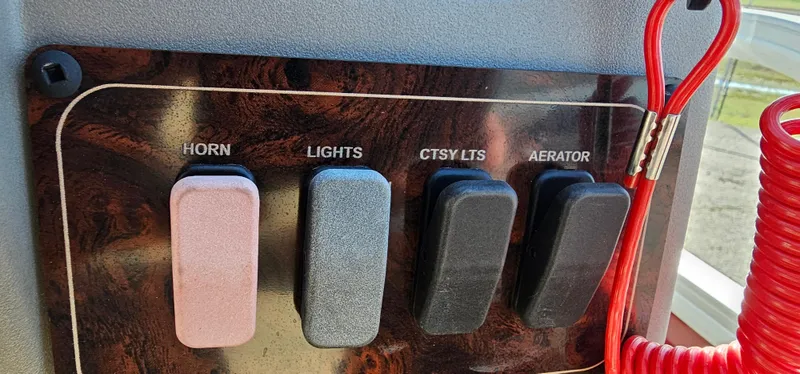 Slide: The Image of Control panel of 2024 Sun Tracker BB-18 boat with switches for horn, lights, and aerator. - 17