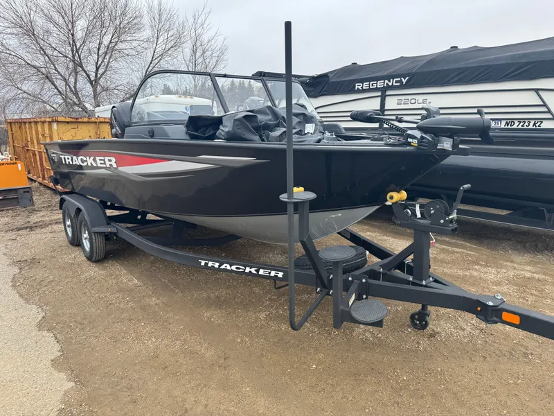 Slide: The Image of 2025 Tracker Targa V-18 Combo boat on trailer, parked outdoors. - 2