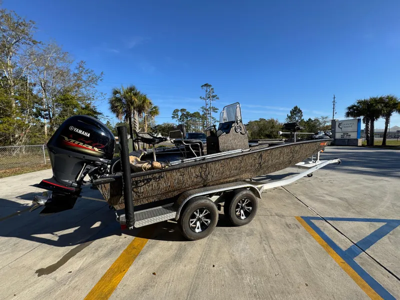Slide: The Image of 2023 Xpress H22B boat on trailer with Yamaha outboard motor, parked outdoors. - 12