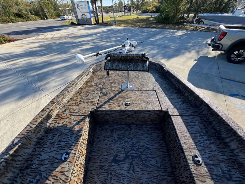 Slide: The Image of 2023 Xpress H22B boat with camouflage interior, parked outdoors in a sunny setting. - 18