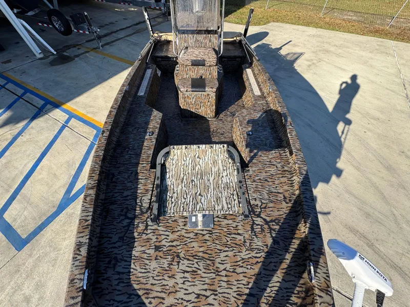 Slide: The Image of 2023 Xpress H22B boat with camouflage interior, parked on concrete surface. - 21