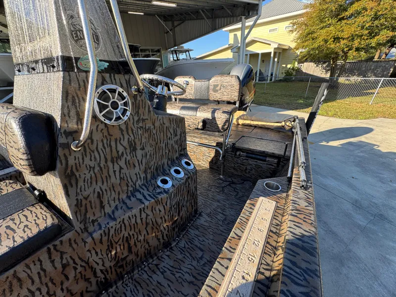 Slide: The Image of 2023 Xpress H22B boat interior with camouflage design, featuring seating and steering console. - 25