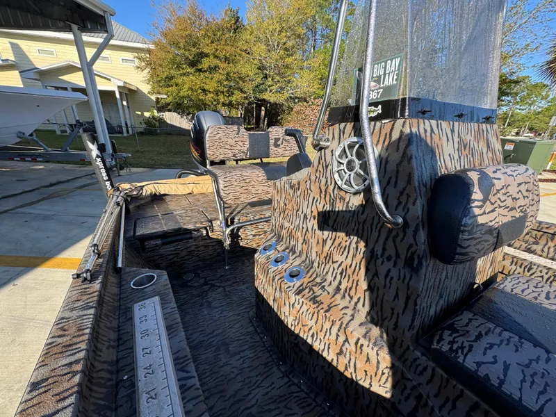 Slide: The Image of 2023 Xpress H22B boat with camouflage interior, parked outdoors. - 26