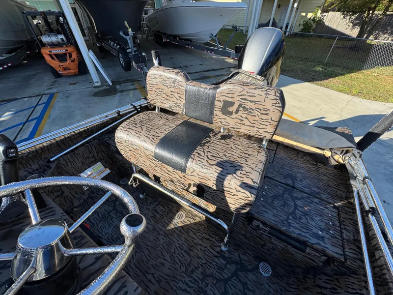 Slide: The Image of 2023 Xpress H22B boat interior with camo seating and steering wheel. - 27