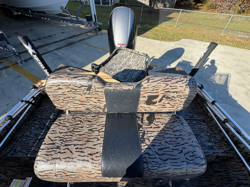 Slide: The Image of 2023 Xpress H22B boat interior with camouflage seating and motor in a sunny outdoor setting. - 28