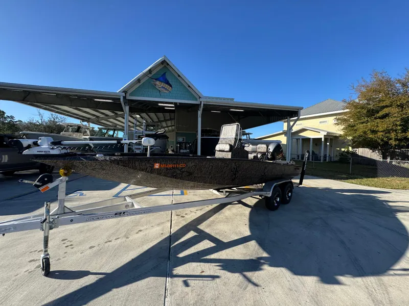 Slide: The Image of 2023 Xpress H22B boat on trailer outside a building under clear blue sky. - 3
