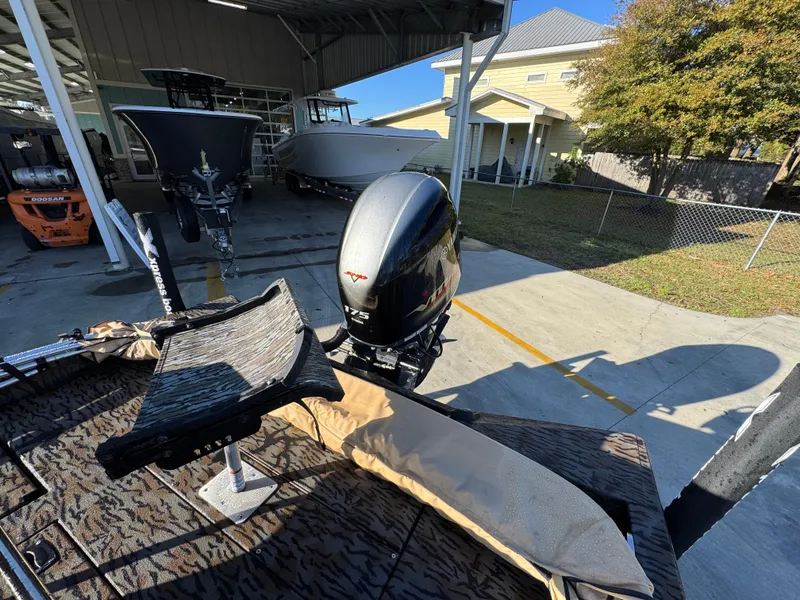 Slide: The Image of 2023 Xpress H22B boat with outboard motor in a sunny outdoor setting. - 32