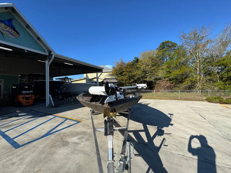 Slide: The Image of 2023 Xpress H22B boat on trailer outside a storage facility under clear blue sky. - 6