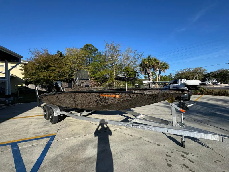 Slide: The Image of 2023 Xpress H22B boat on trailer, parked outdoors under clear sky. - 8