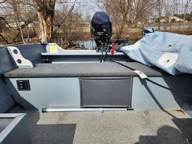 Slide: The Image of 2021 Starcraft 16 SF DLX boat interior with motor, near a lake. - 11