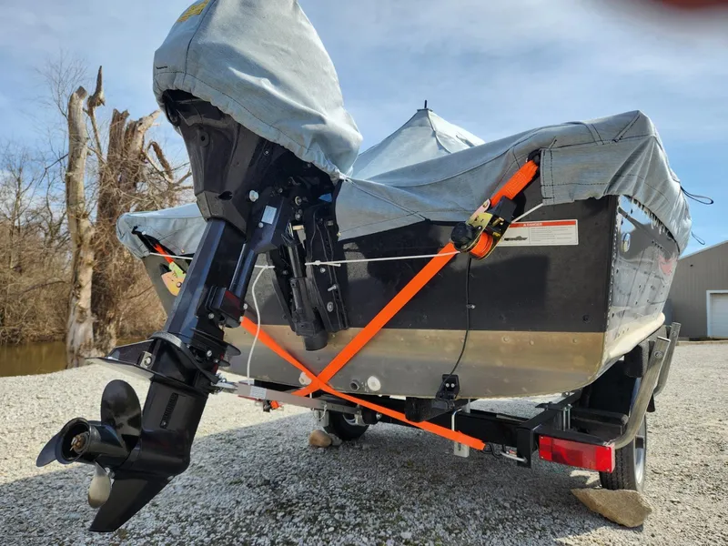 Slide: The Image of 2021 Starcraft 16 SF DLX boat on trailer, covered and secured with orange straps. - 17