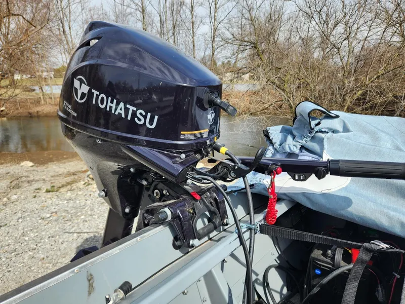 Slide: The Image of Tohatsu outboard motor on 2021 Starcraft 16 SF DLX boat by a riverbank. - 3