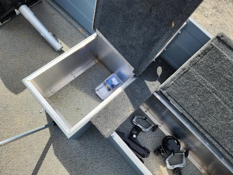 Slide: The Image of Open storage compartments in a 2021 Starcraft 16 SF DLX boat, showing interior details. - 7