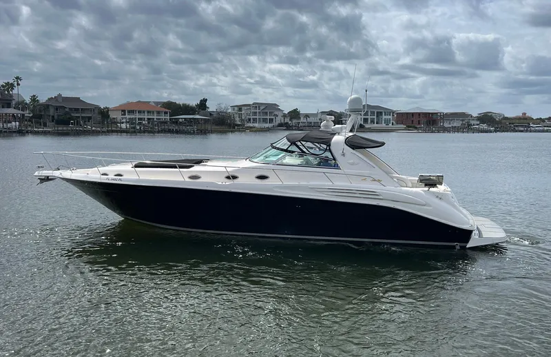 Slide: The Image of 1997 Sea Ray 450 Sundancer yacht on calm water under cloudy skies. - 3