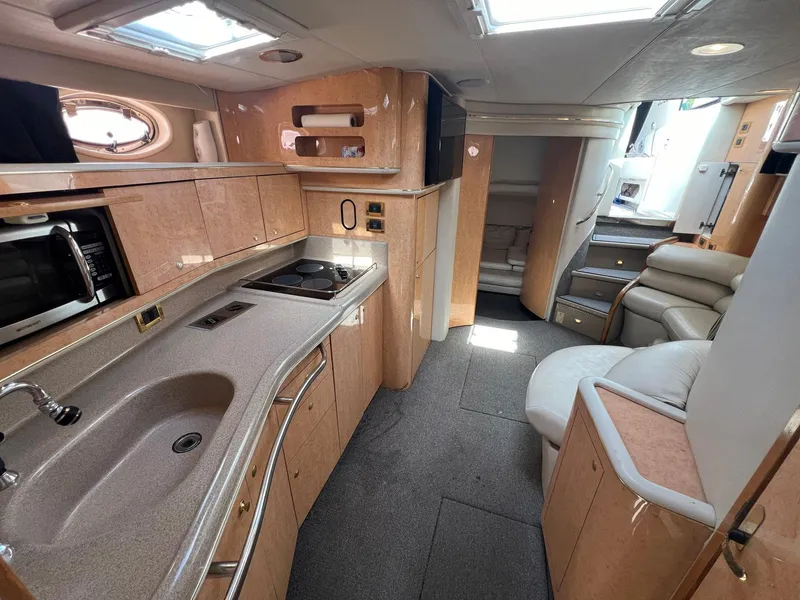Slide: The Image of Interior of 1997 Sea Ray 450 Sundancer yacht with modern kitchen and seating area. - 5