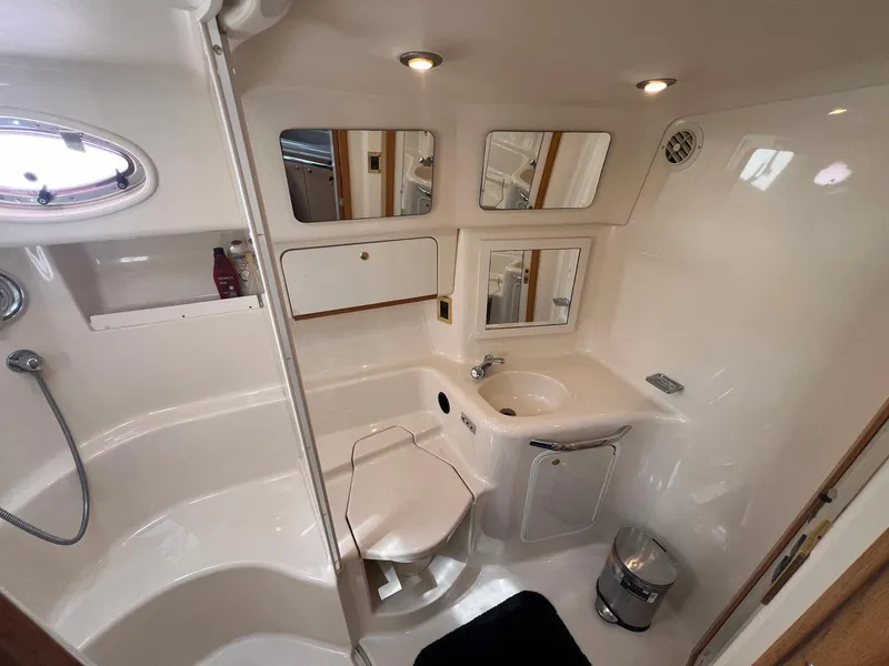 Slide: The Image of Luxurious bathroom in 1997 Sea Ray 450 Sundancer yacht, featuring shower, sink, and toilet. - 7