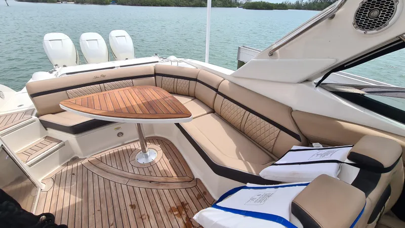 Slide: The Image of 2017 Sea Ray SLX 350 OB boat interior with elegant seating and wooden table. - 12