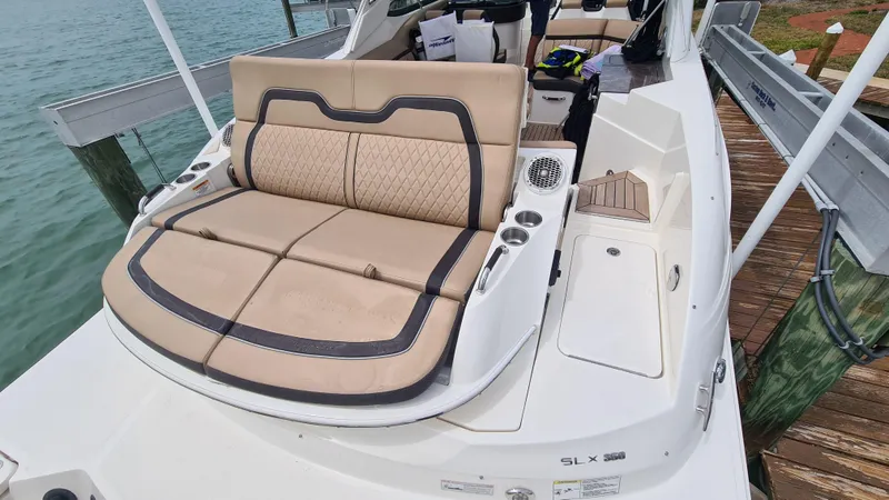 Slide: The Image of 2017 Sea Ray SLX 350 OB boat with beige seating, docked by the water. - 16