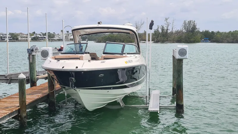 Slide: The Image of 2017 Sea Ray SLX 350 OB boat docked on a lift in a serene marina. - 3