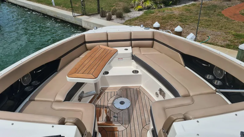 Slide: The Image of 2017 Sea Ray SLX 350 OB boat with spacious seating and wooden table on deck. - 7