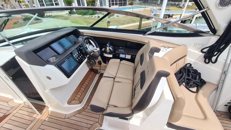 Slide: The Image of 2017 Sea Ray SLX 350 OB boat cockpit with modern controls and beige seating. - 8