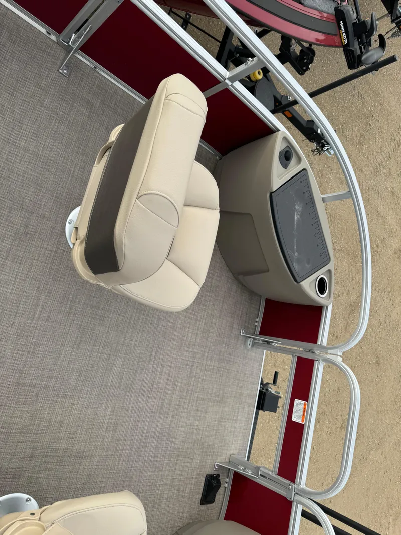 Slide: The Image of 2024 Sun Tracker Bass Buggy 18 DLX pontoon boat interior with beige seating and red accents. - 11