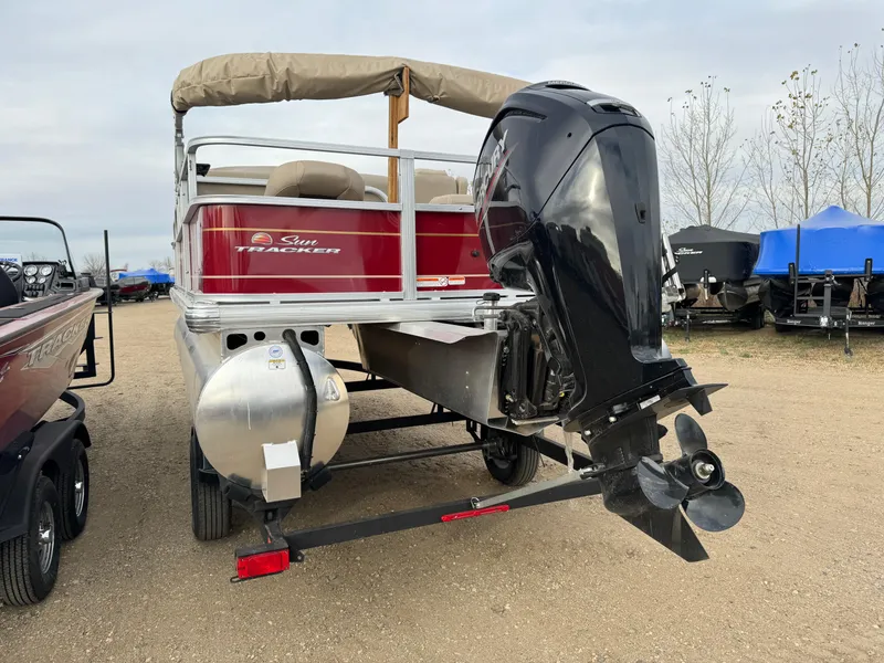 Slide: The Image of 2024 Sun Tracker Bass Buggy 18 DLX pontoon boat with outboard motor, rear view. - 2