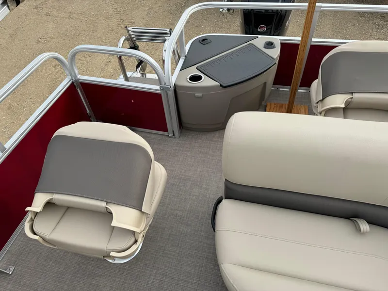 Slide: The Image of 2024 Sun Tracker Bass Buggy 18 DLX pontoon boat interior with beige seating and red accents. - 6